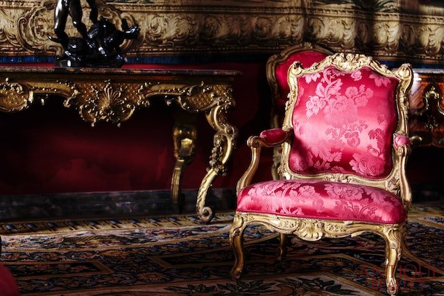 Antyczny fotel w stylu ludwikowskim z czerwonym obiciem